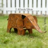 Rustic elephant garden statue in a flower bed Rustic elephant garden statue with aged finish in a garden