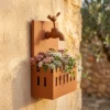 Rustic faucet wall planter with bird detail Rustic faucet wall planter with bird detail and succulents on a garden wall