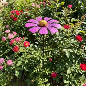 Painted flower garden stake in an outdoor flower bed